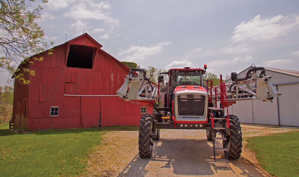 Front view of Apache Sprayer sitting in front of red barn